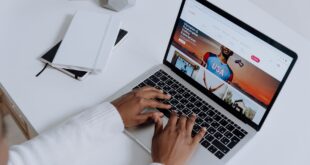 person using a macbook pro on a white table